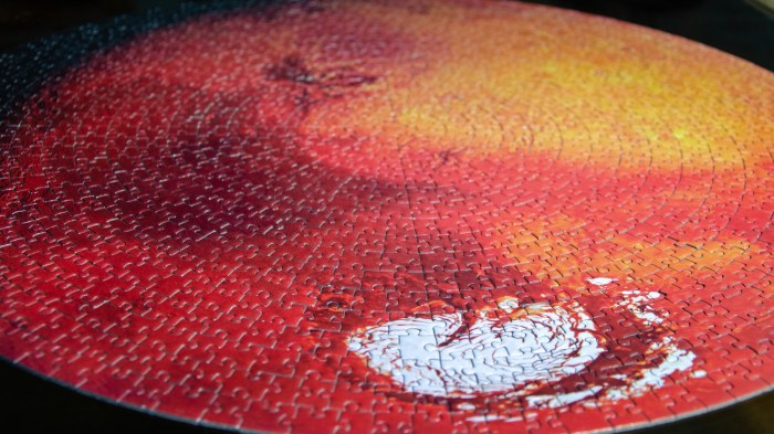 Mars as a puzzle in red orange and yellow colours, with its white vortex in the front.